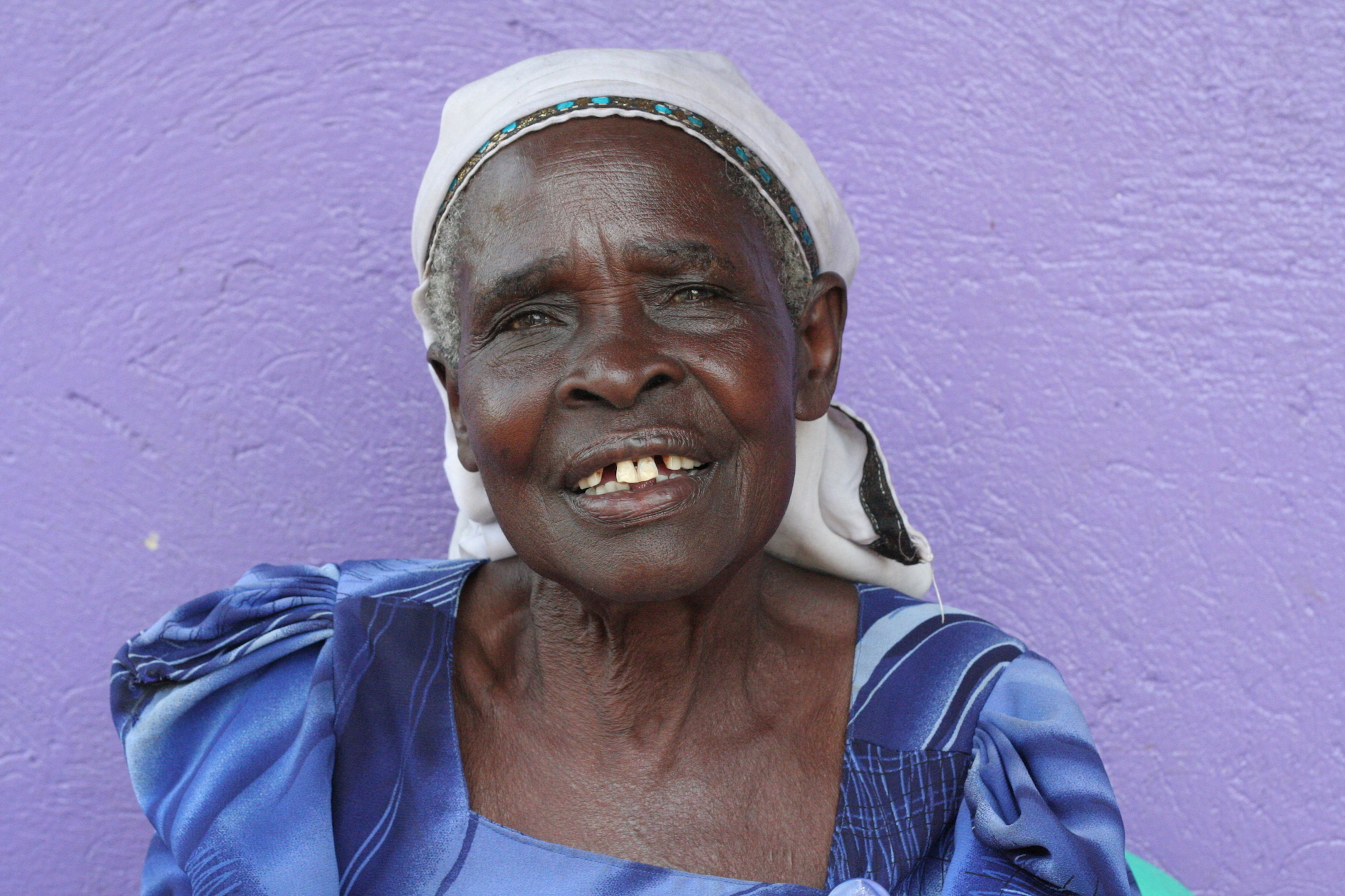 Woman laughing in front of a purple wall