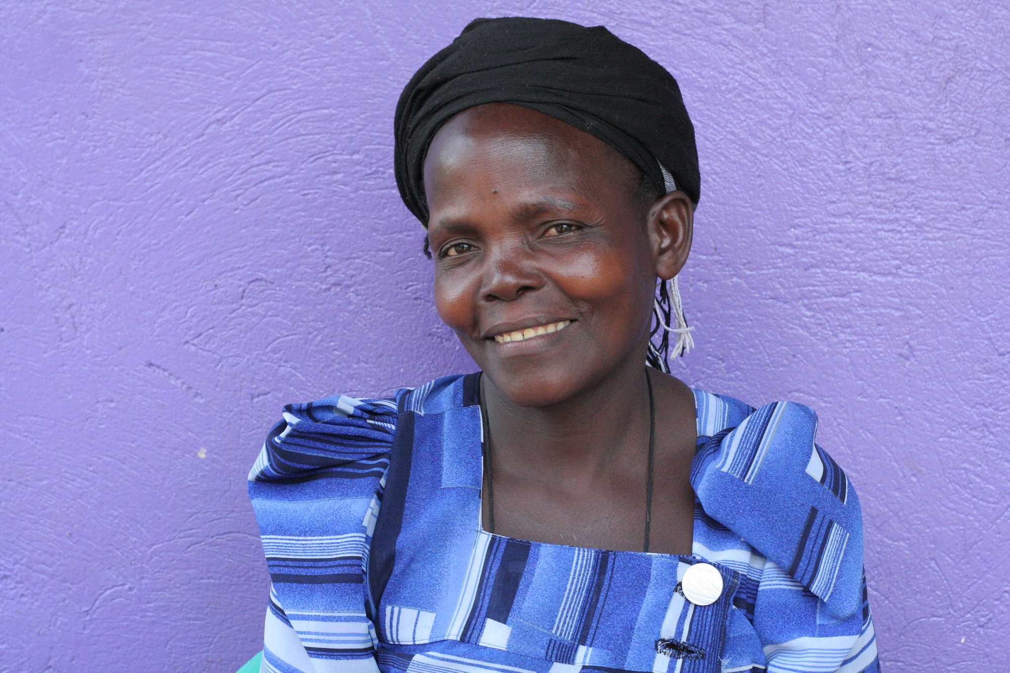 Woman smiling in front of a purple wall