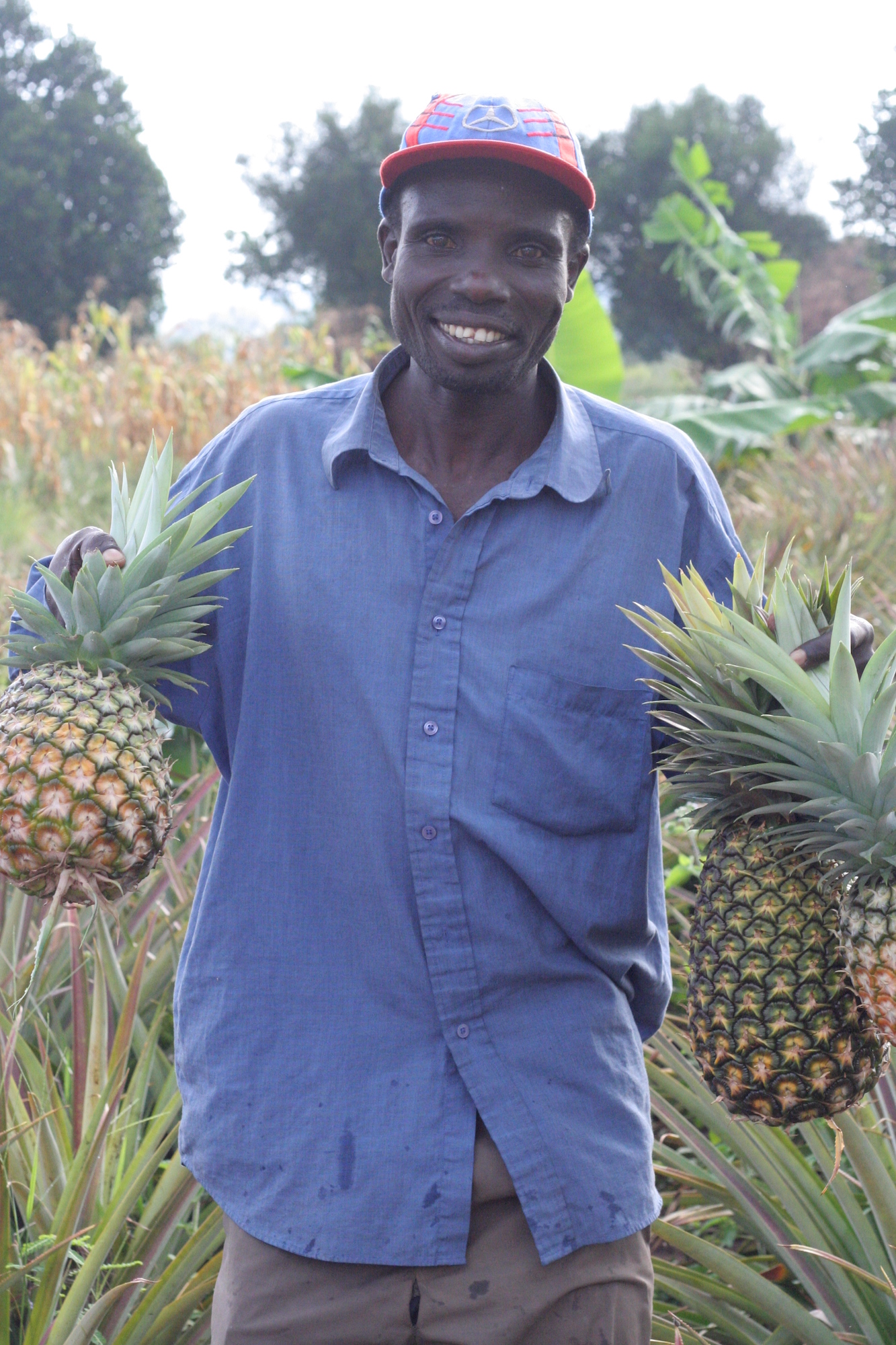 Man smiling with pineapples in his hands
