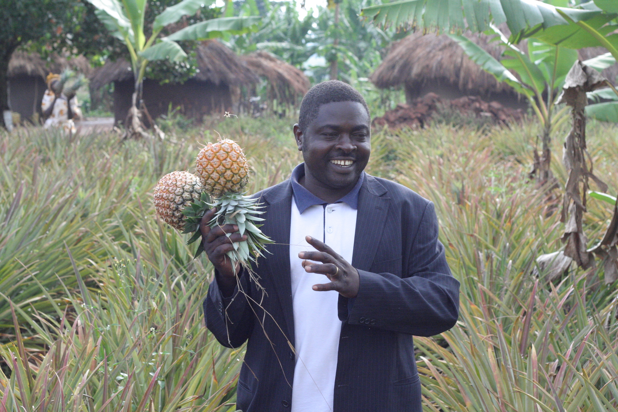 Man smiling with pineapples in his hands