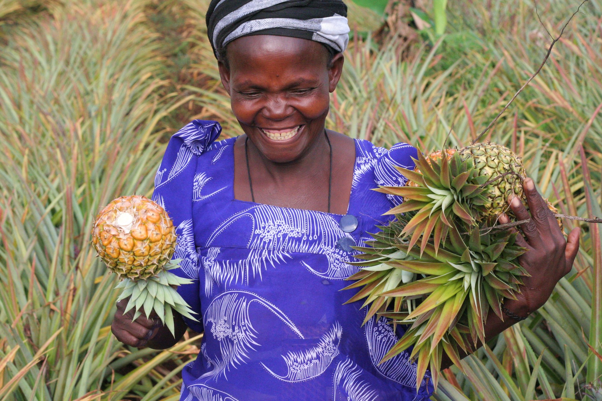 Woman smiling holding pineapples