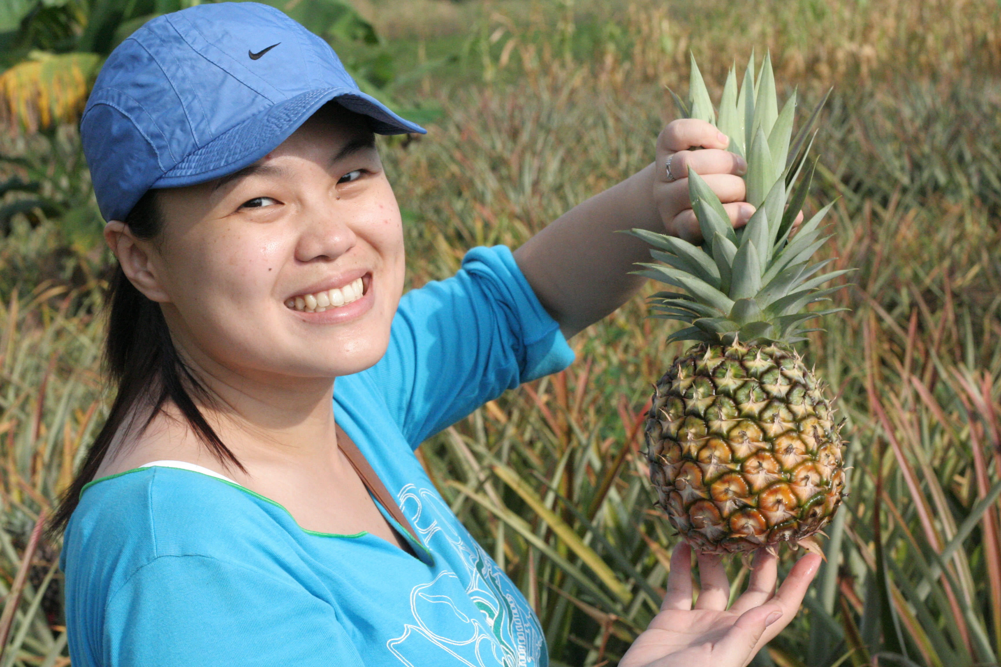 Woman smiling holding a pineapple