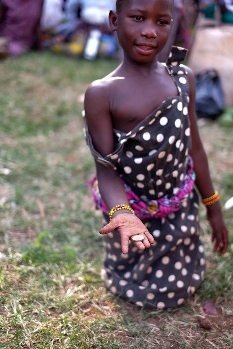 A young girl holding a coin in her hand