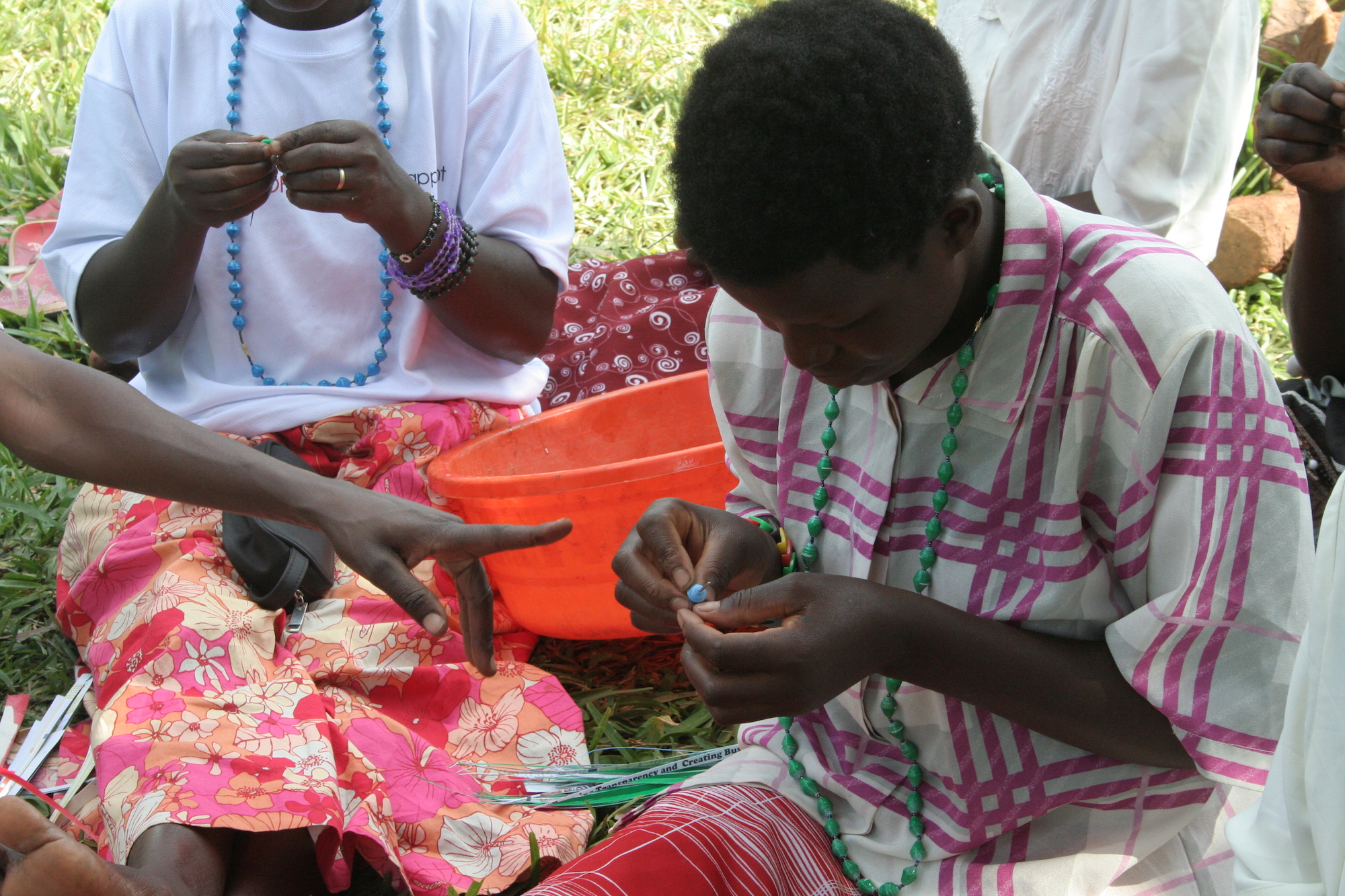 Woman stringing beads in her lap