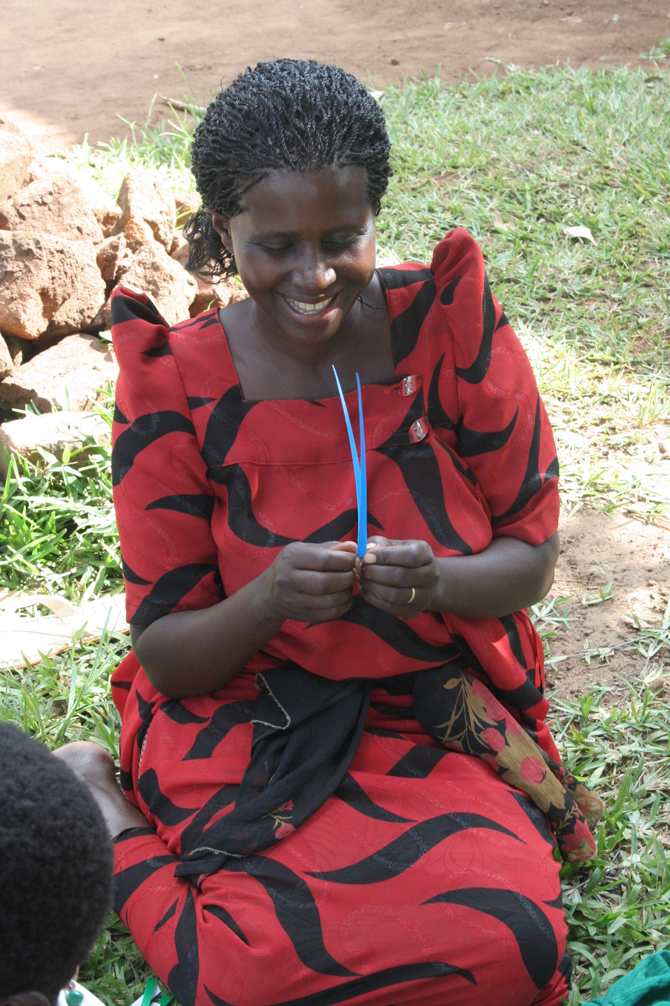 Smiling woman making a blue paper bead