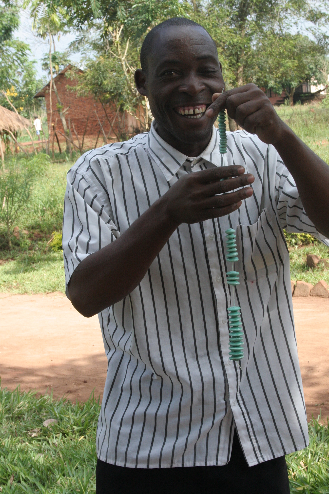Smiling man holding a strand of beads