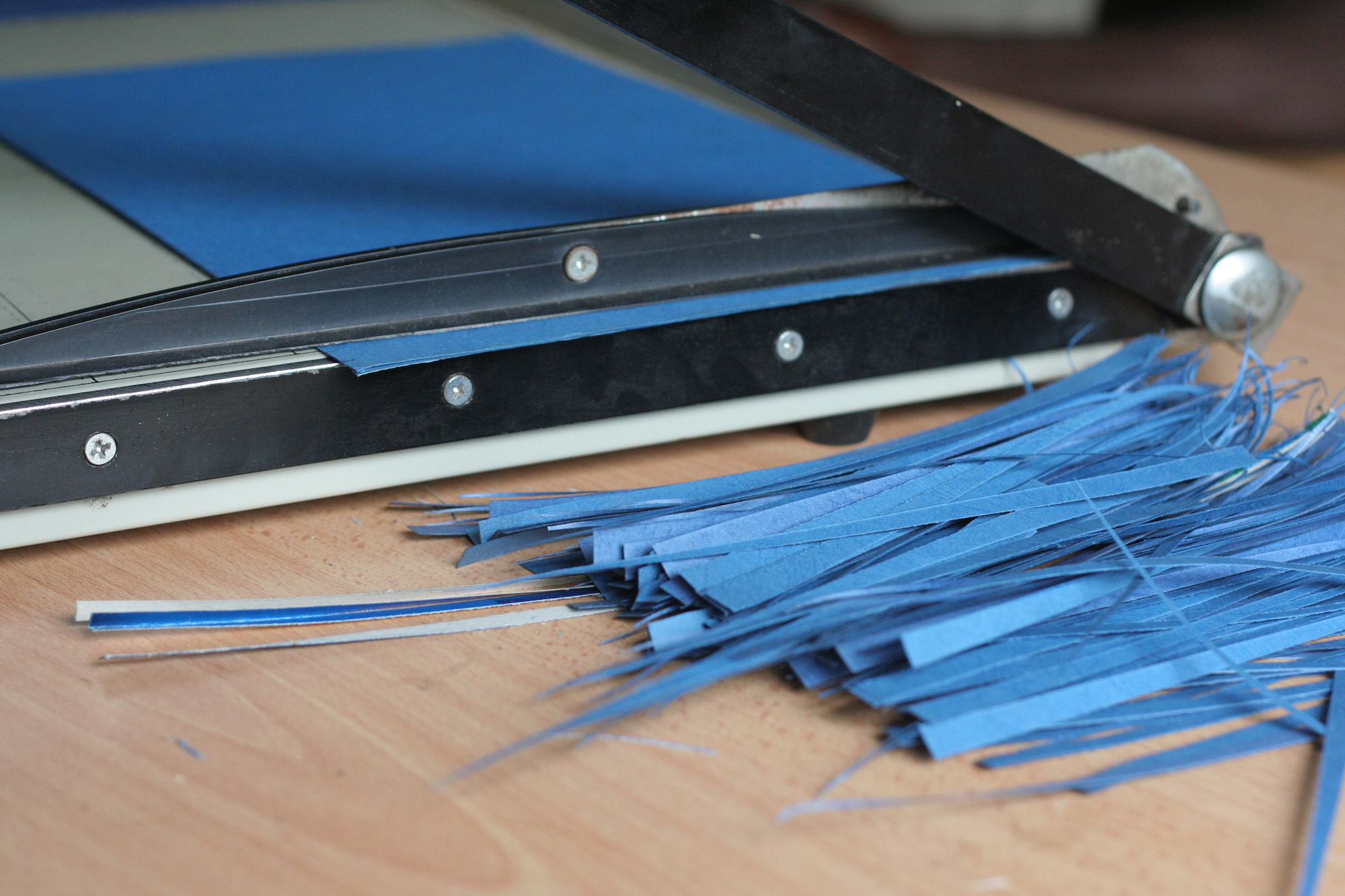 Strips of blue paper next to a paper cutter