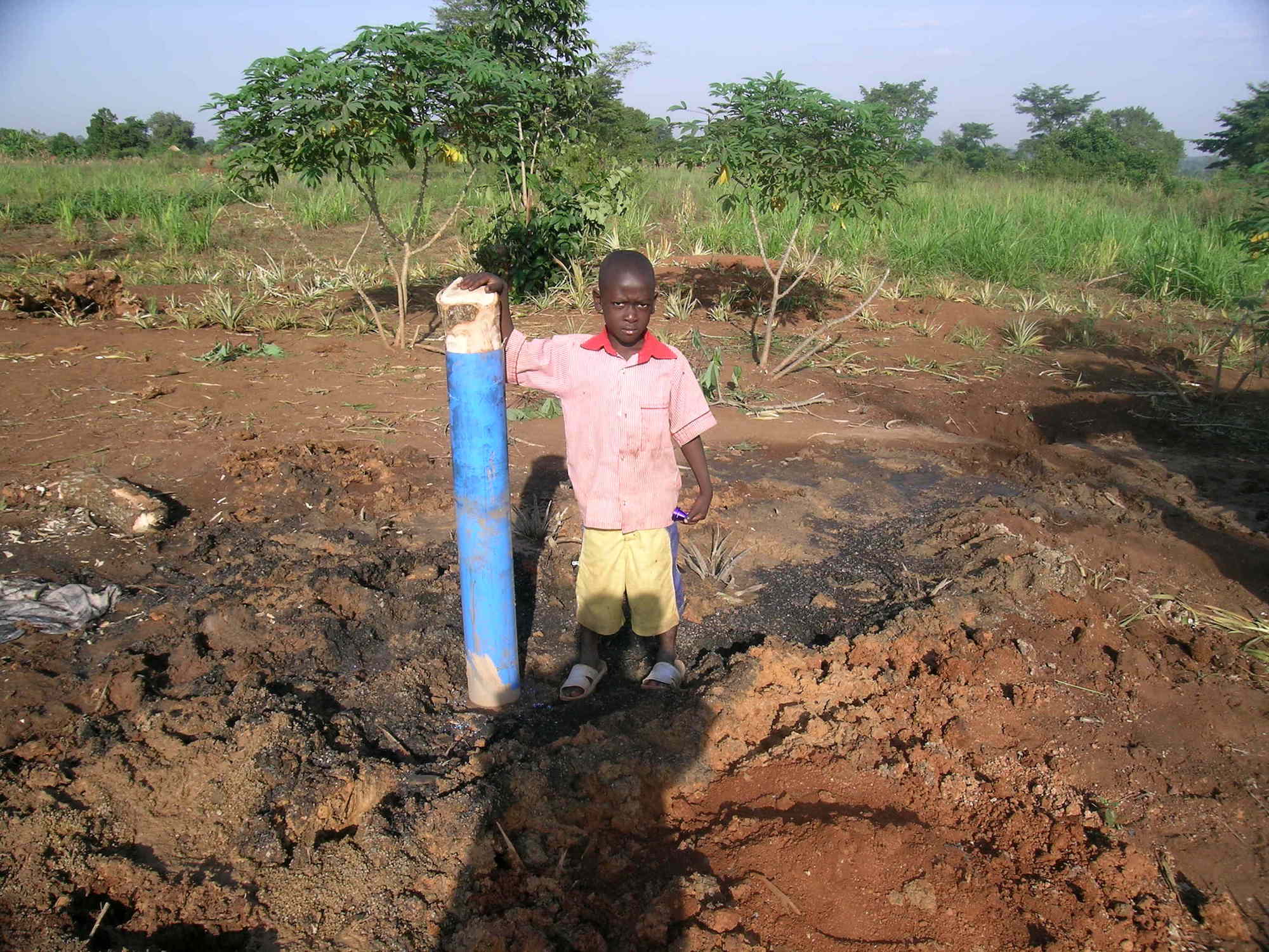 Young boy standing at pump site