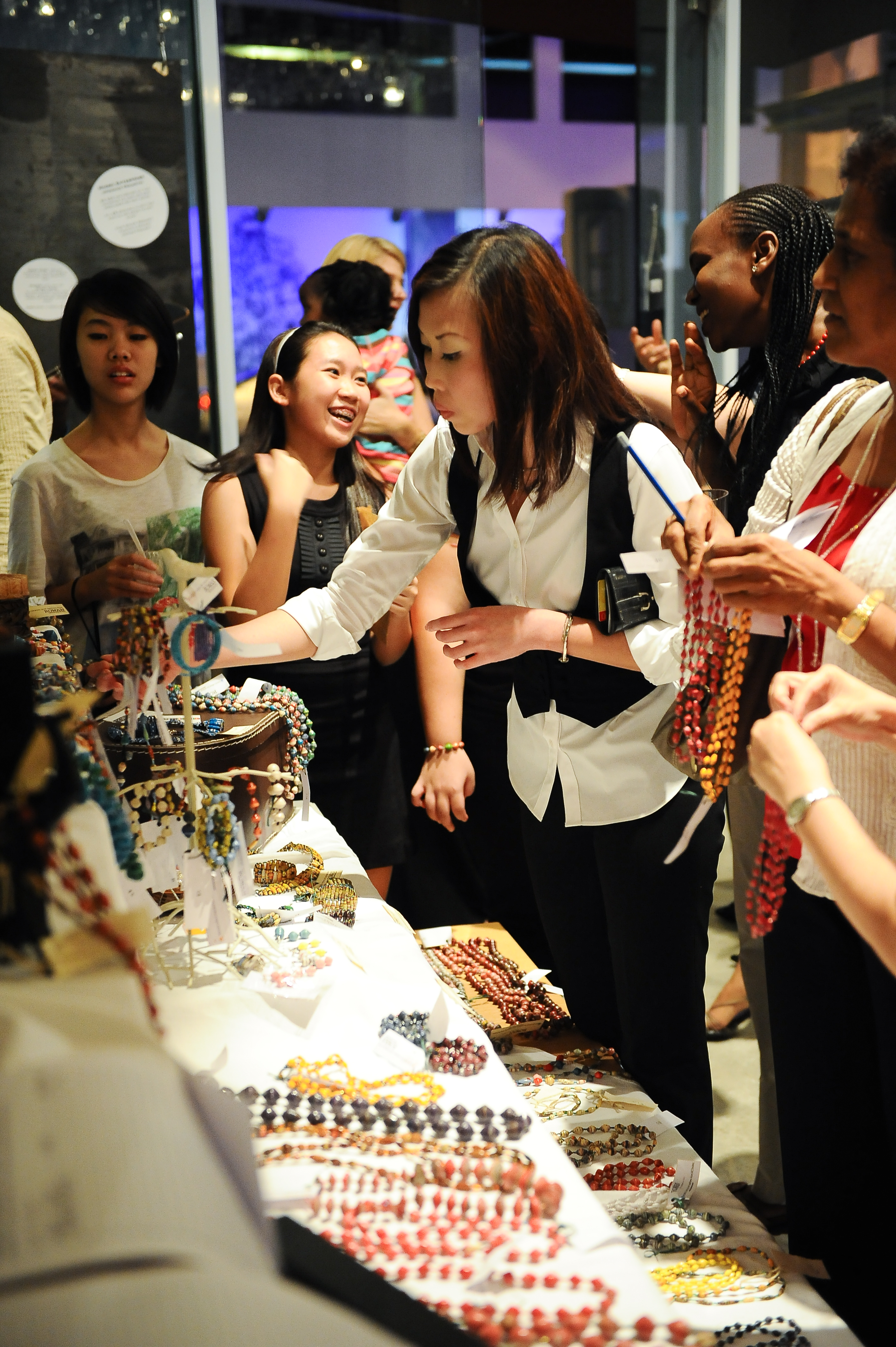 People looking at ROWAN beads & merchandise on a table