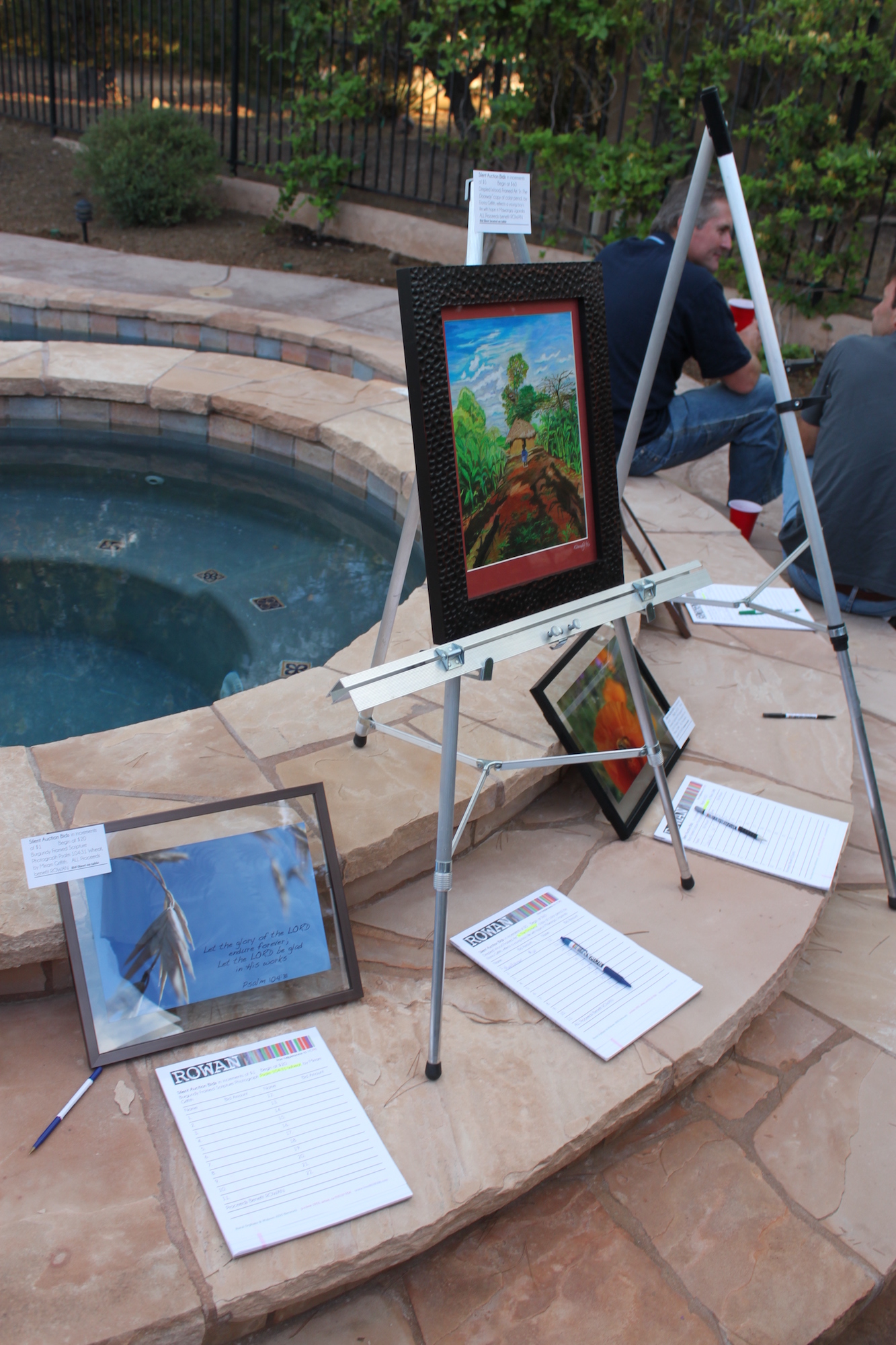 Artwork on easels around a jacuzzi