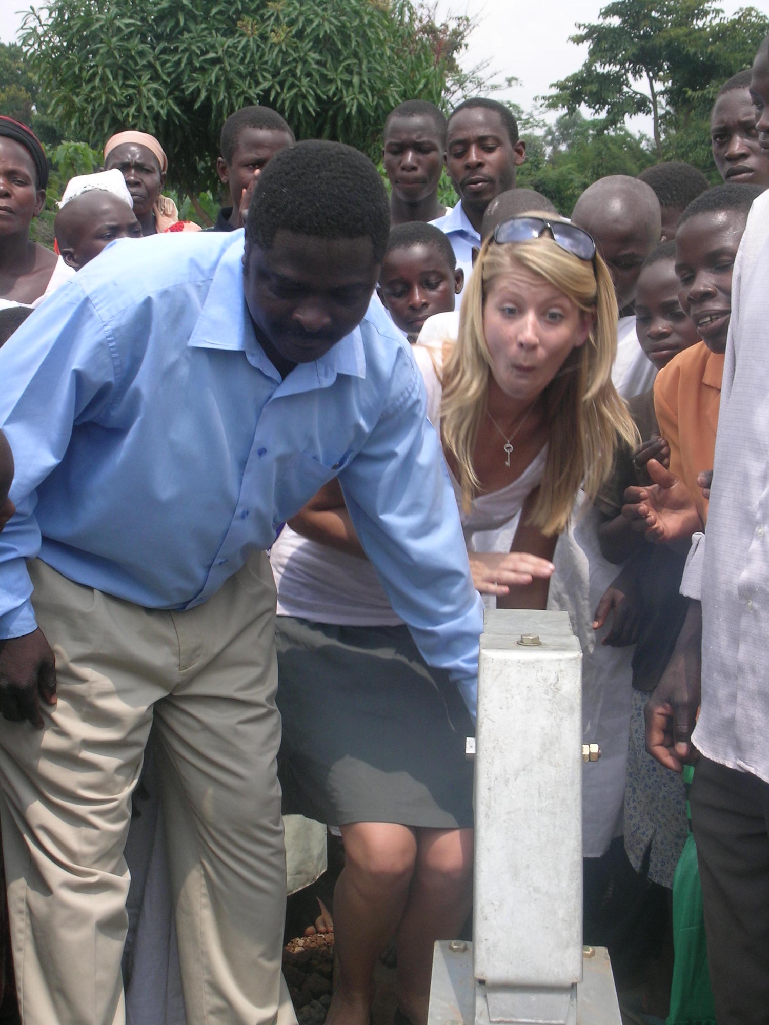 Crowd of people around a water pump