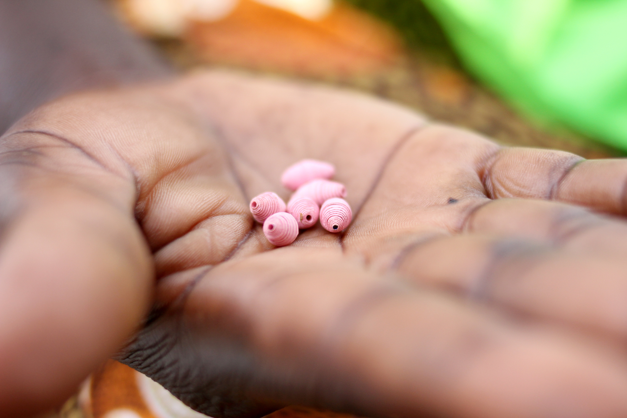 Close up of pink beads in the palm of a hand