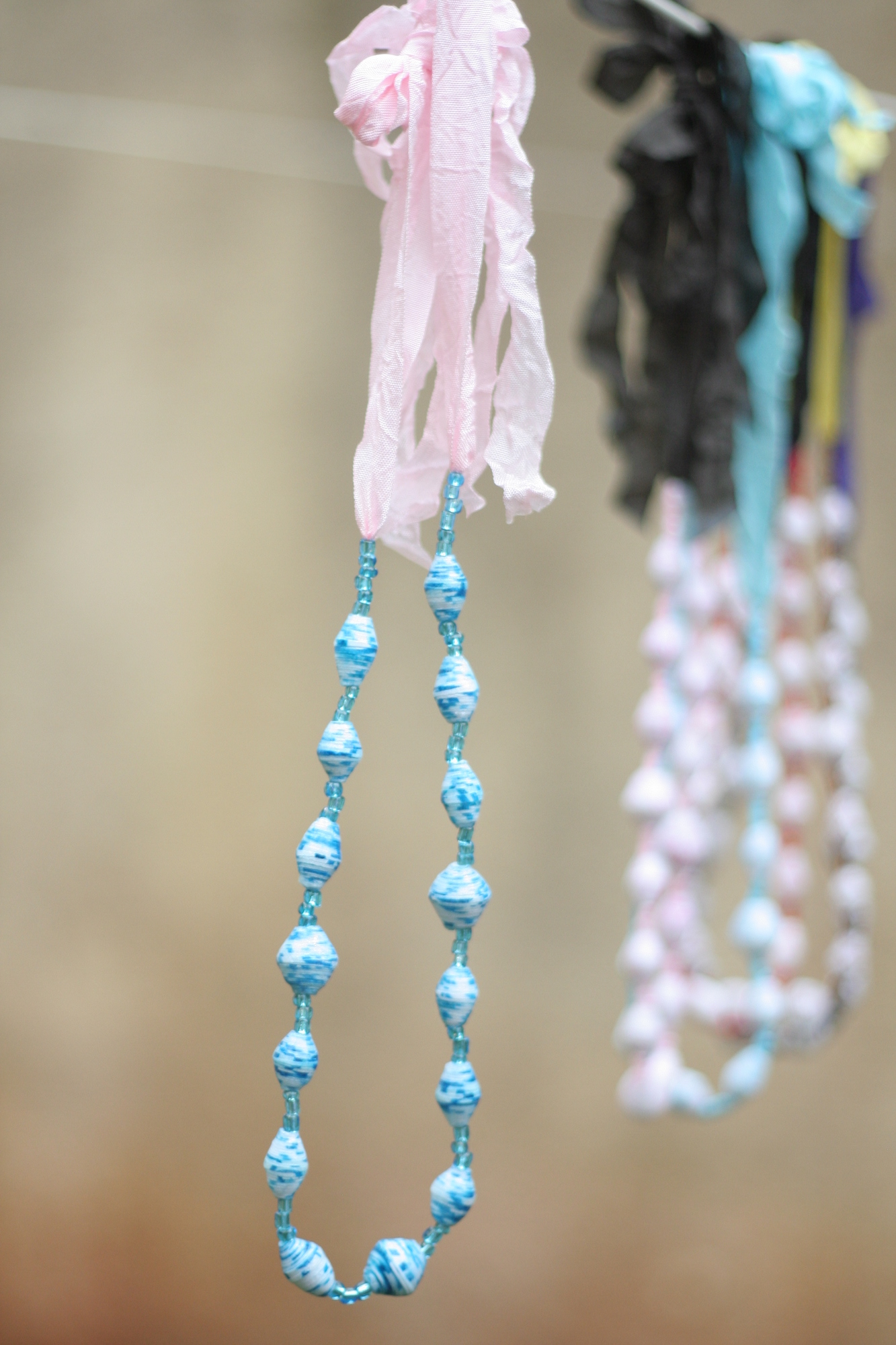Beaded necklace, blue beads on pink ribbon