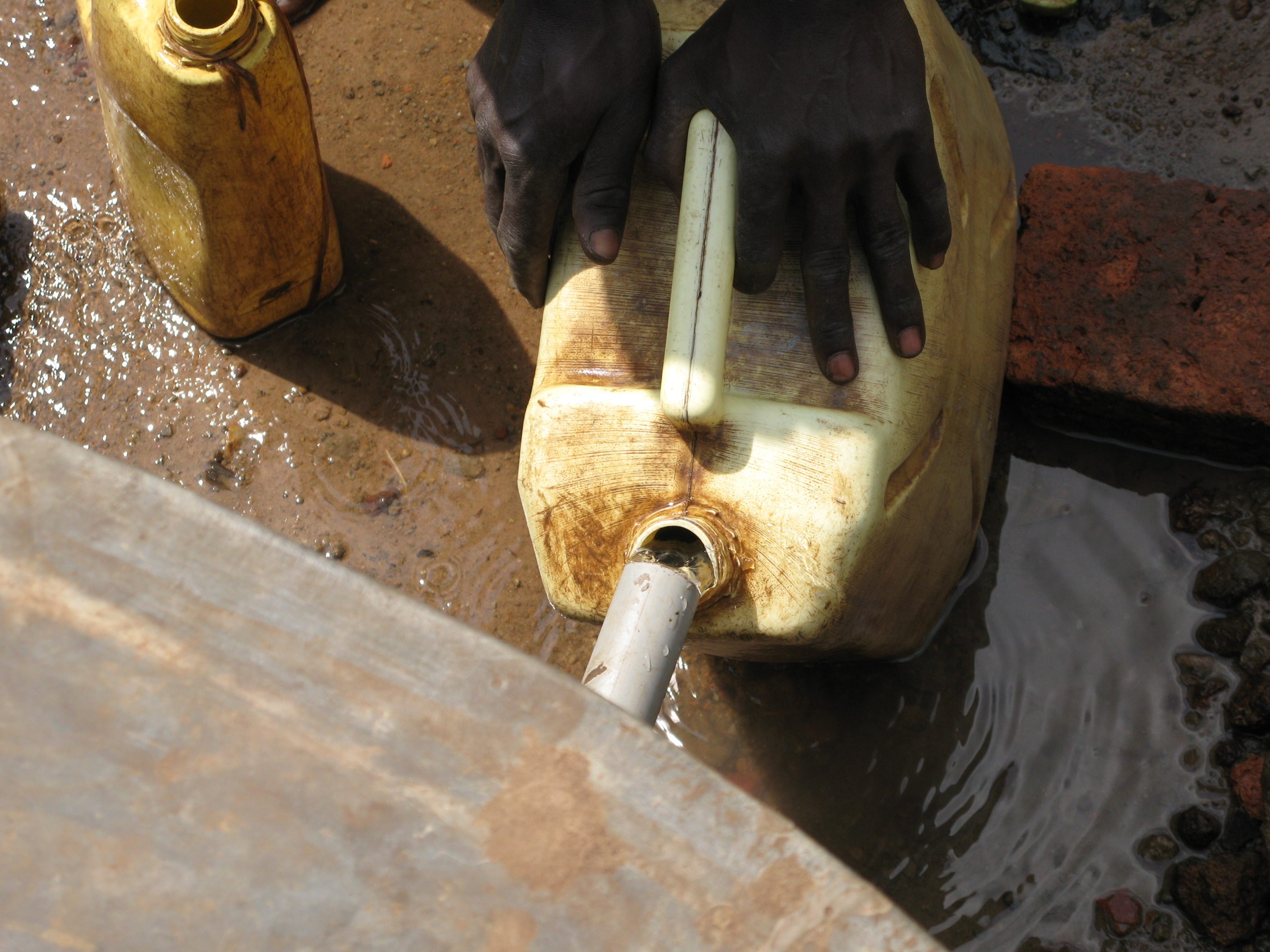 Close up of a Jerry Can being filled at a well