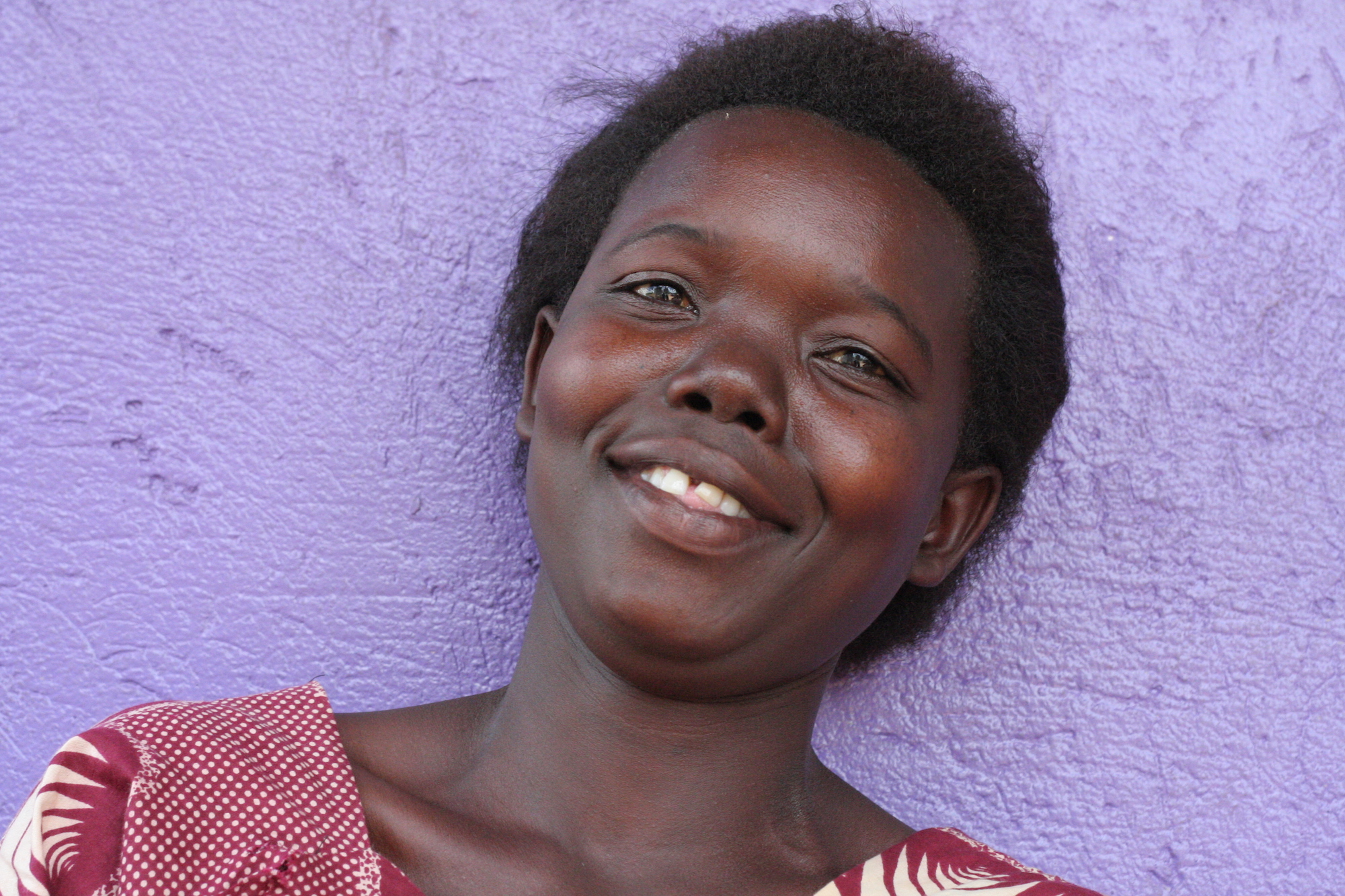 Smiling woman in front of a purple wall