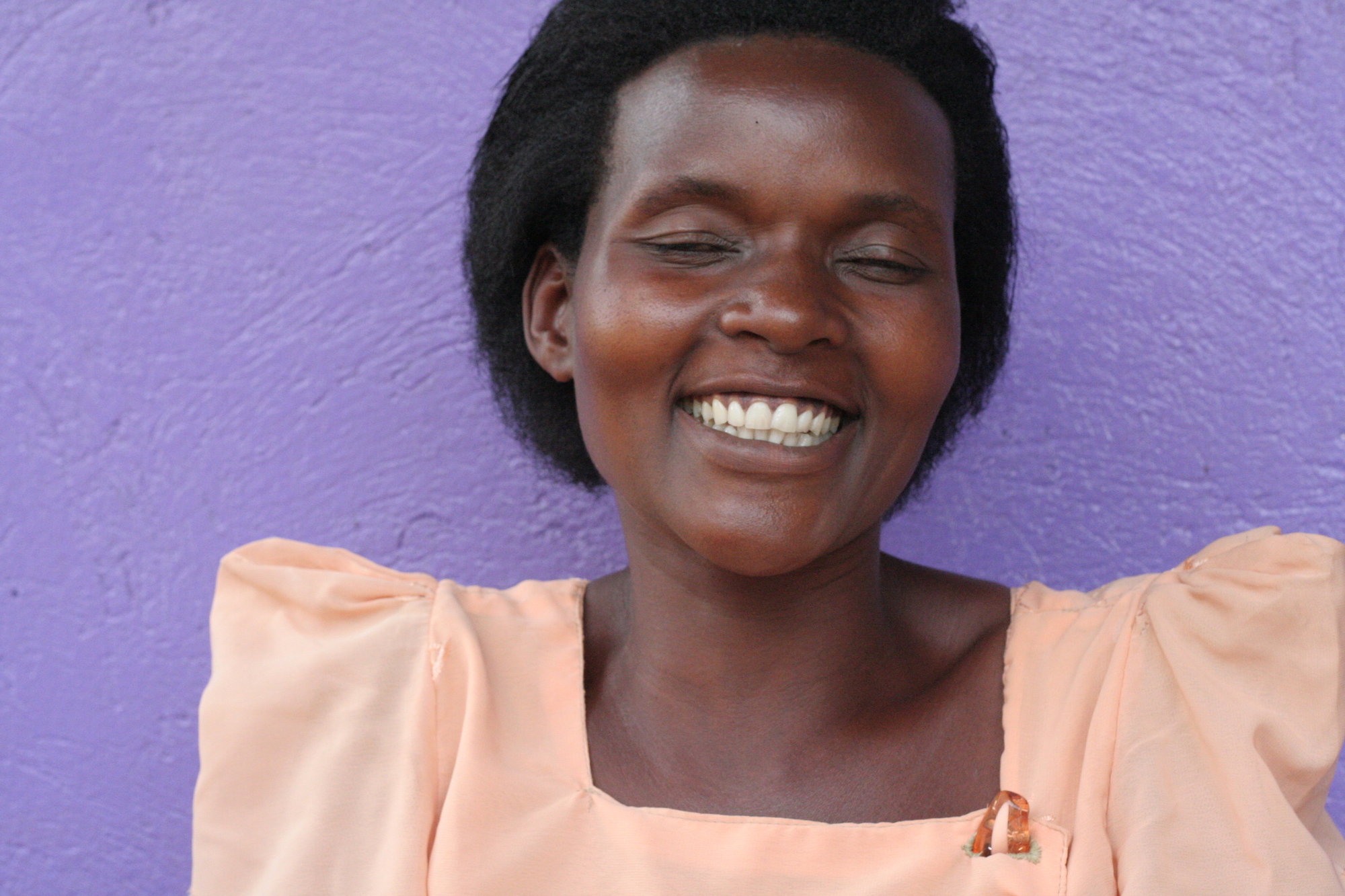 Smiling woman in front of a purple wall