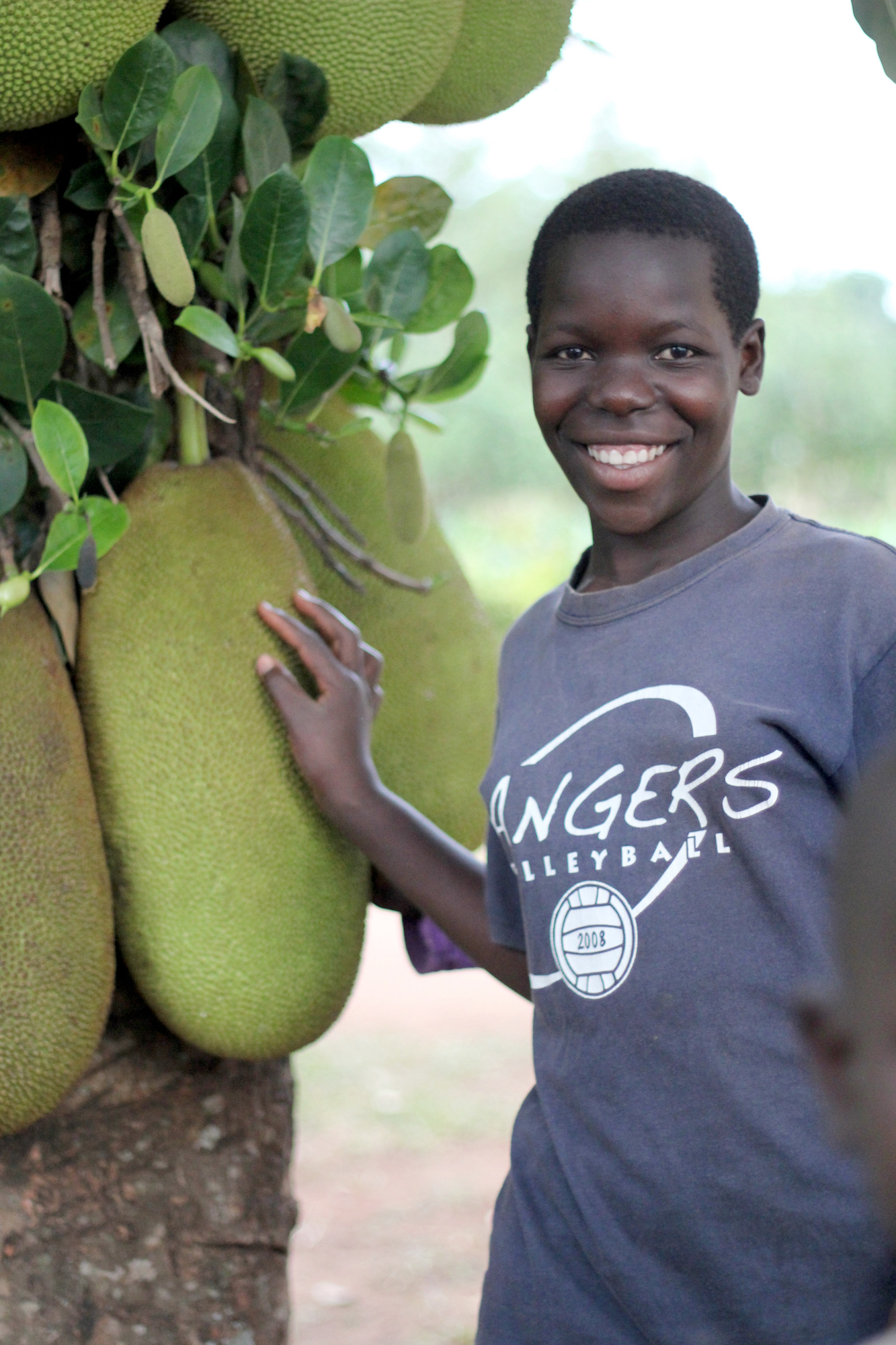 Young woman standing under a breadfruit tree