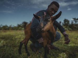 A man holding a goat in Uganda