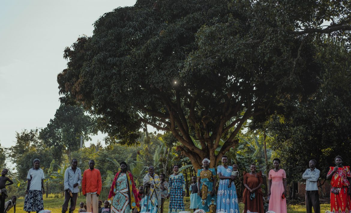 Group of people in Uganda standing behind bags of food
