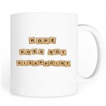 White mug with the words, "Hope does not disappoint" written on it in scrabble pieces