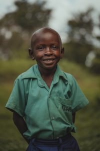 Little boy standing on a field in Uganda