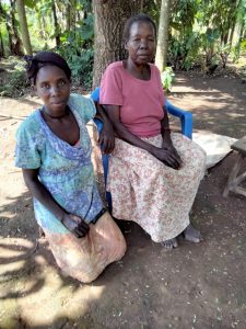 Two women sitting under a tree in Uganda