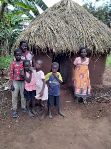 A woman and her five children in front of their home in Uganda